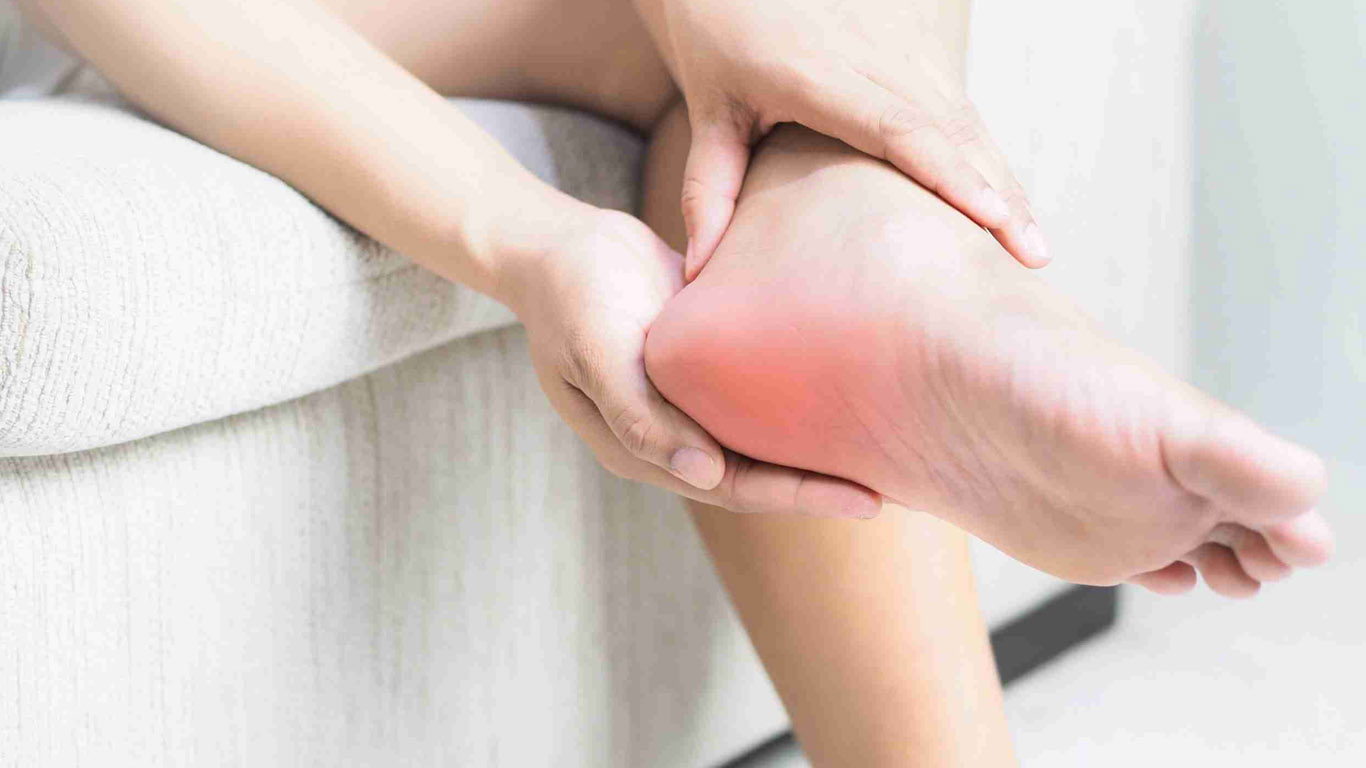 A teenage boy has a heel that hurts, probably from sports.