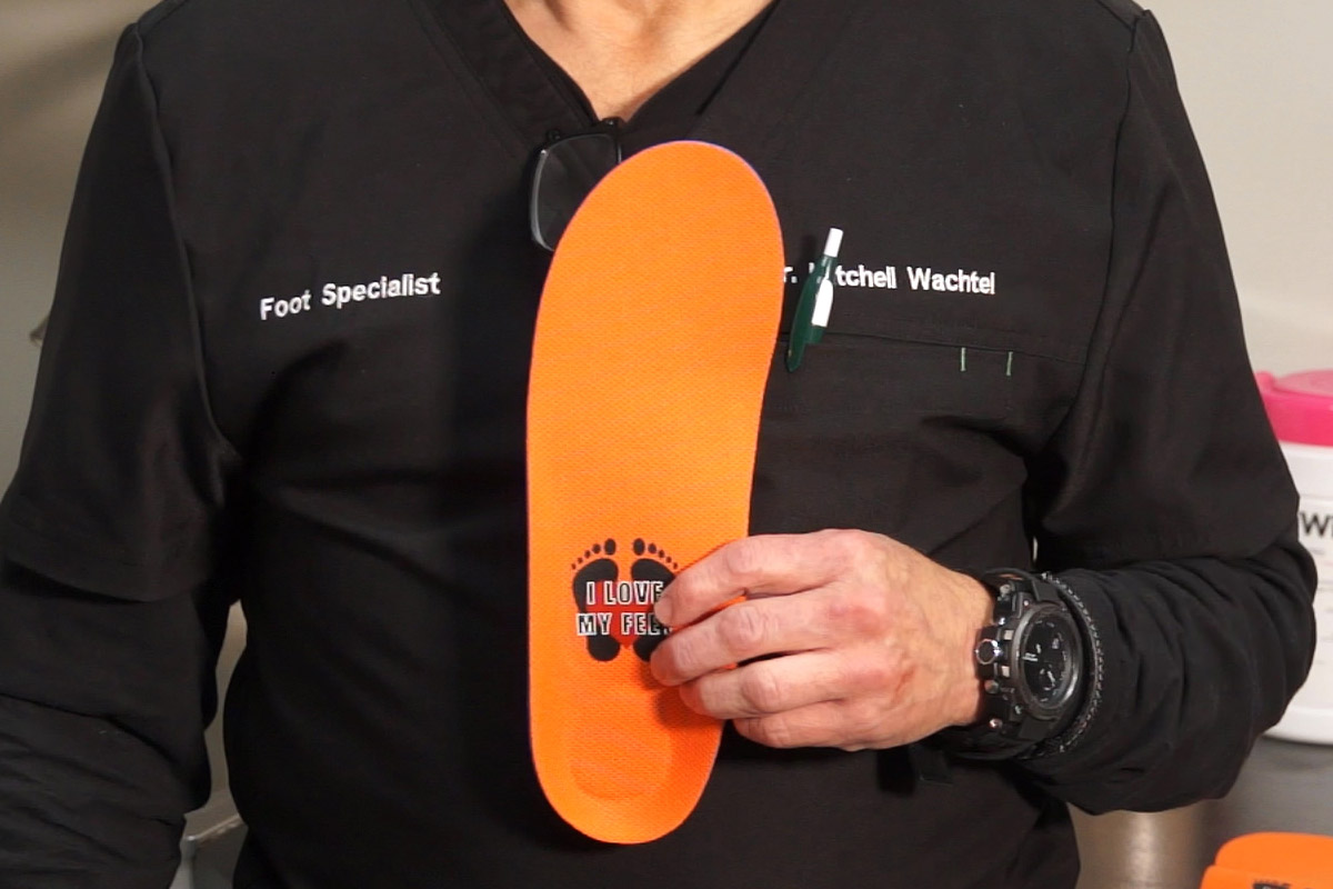 Dr. Mitchell Wachtel holds up a pair of custom orthotics.