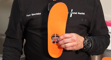 Dr. Mitchell Wachtel holds a Custom Orthotics product.