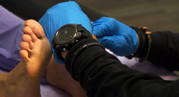 Dr. Mitchell Wachtel examines a patient over tendon conditions.